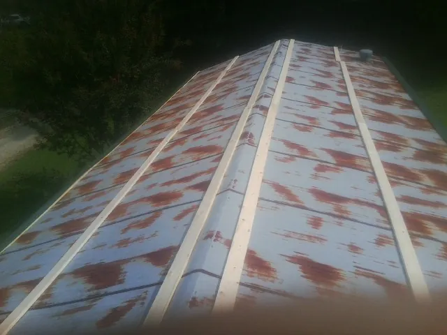 Rusted metal roof panels with new wood purlins before replacement — Storm Damage Roof Repair in Central Islip by Roofing Brothers