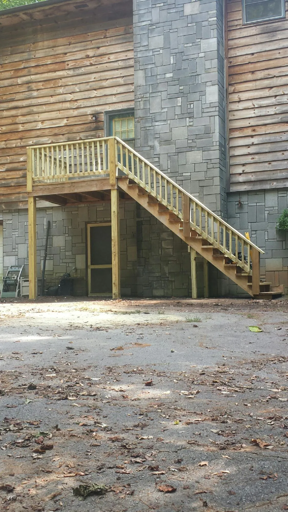 New pressure treated deck and stair landing on a log home in Central Islip