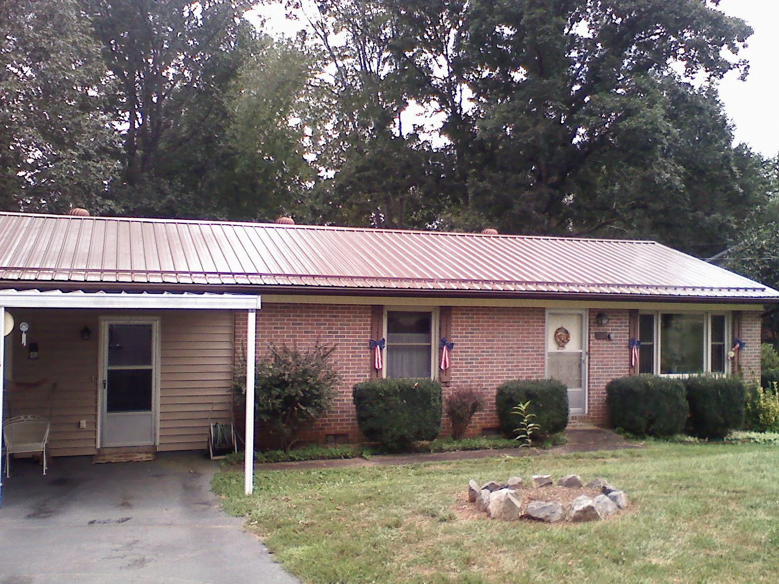 Bronze metal roof and carport on a brick ranch home — Roof Repair work by our crew in Central Islip